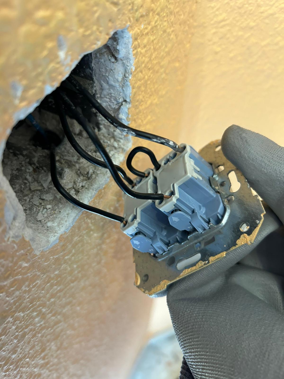 Electricista en Badajoz sustituyendo un enchufe averiado en la pared